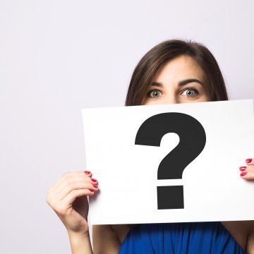 woman holding sign with question mark truecredit credit monitoring service